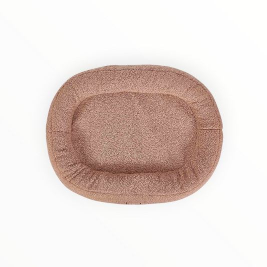 Cama oval de borreguito con borde acolchado e interior impermeable